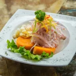 Plato de ceviche peruano con camote, choclo y cebolla morada