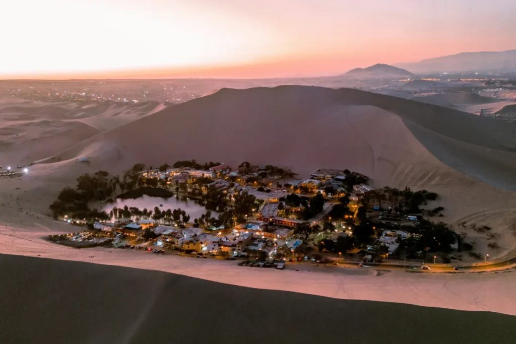 Oasis y dunas de Huacachina iluminados durante el atardecer en Ica