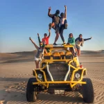 Grupo de viajeros sobre un buggy durante un tour por las dunas de Huacachina