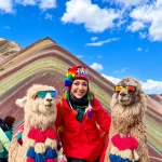 Viajera con llamas frente a la Montaña de 7 Colores Vinicunca